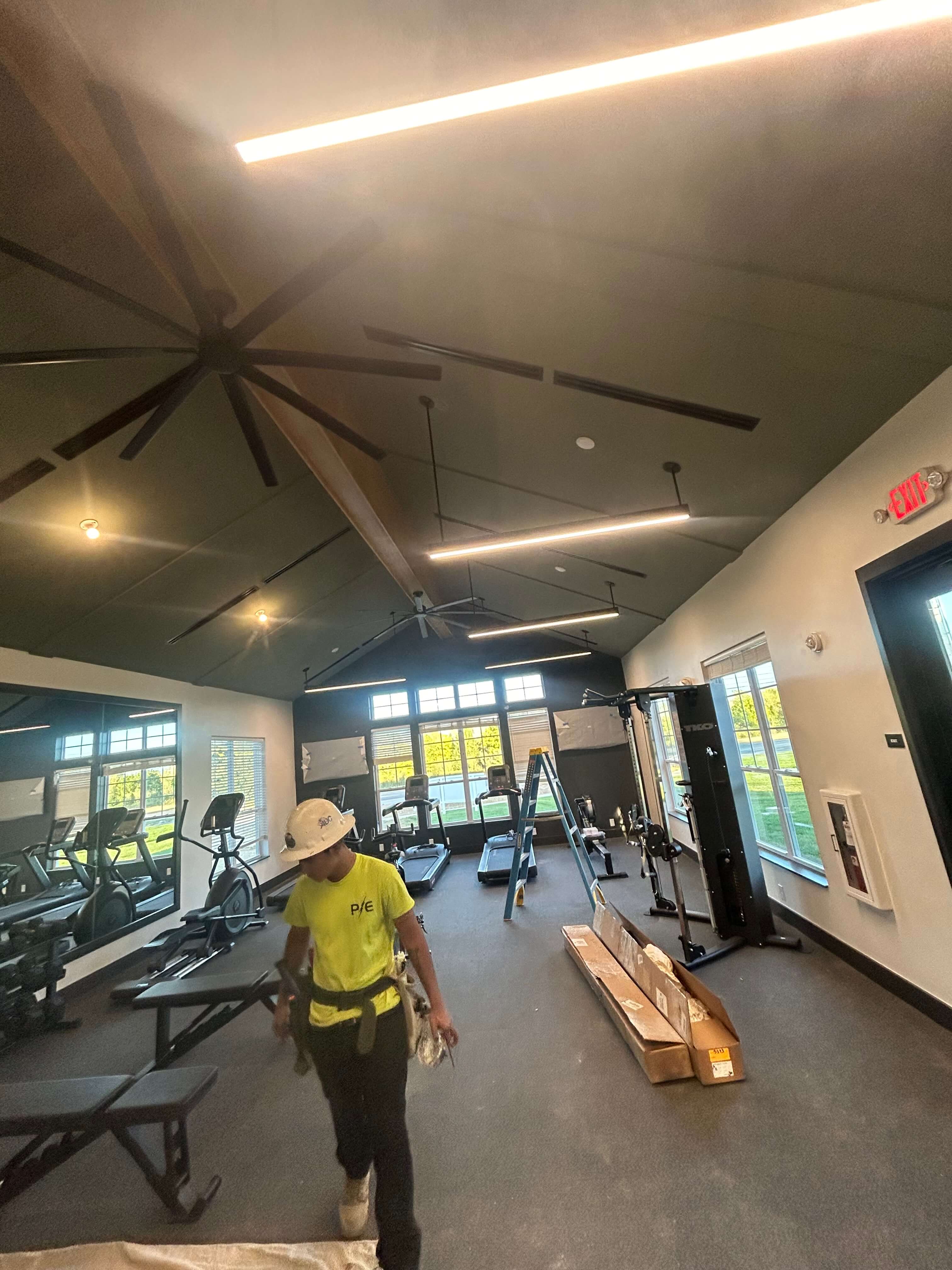 Electrician arriving with tools to a clean, organized jobsite inside a fitness facility