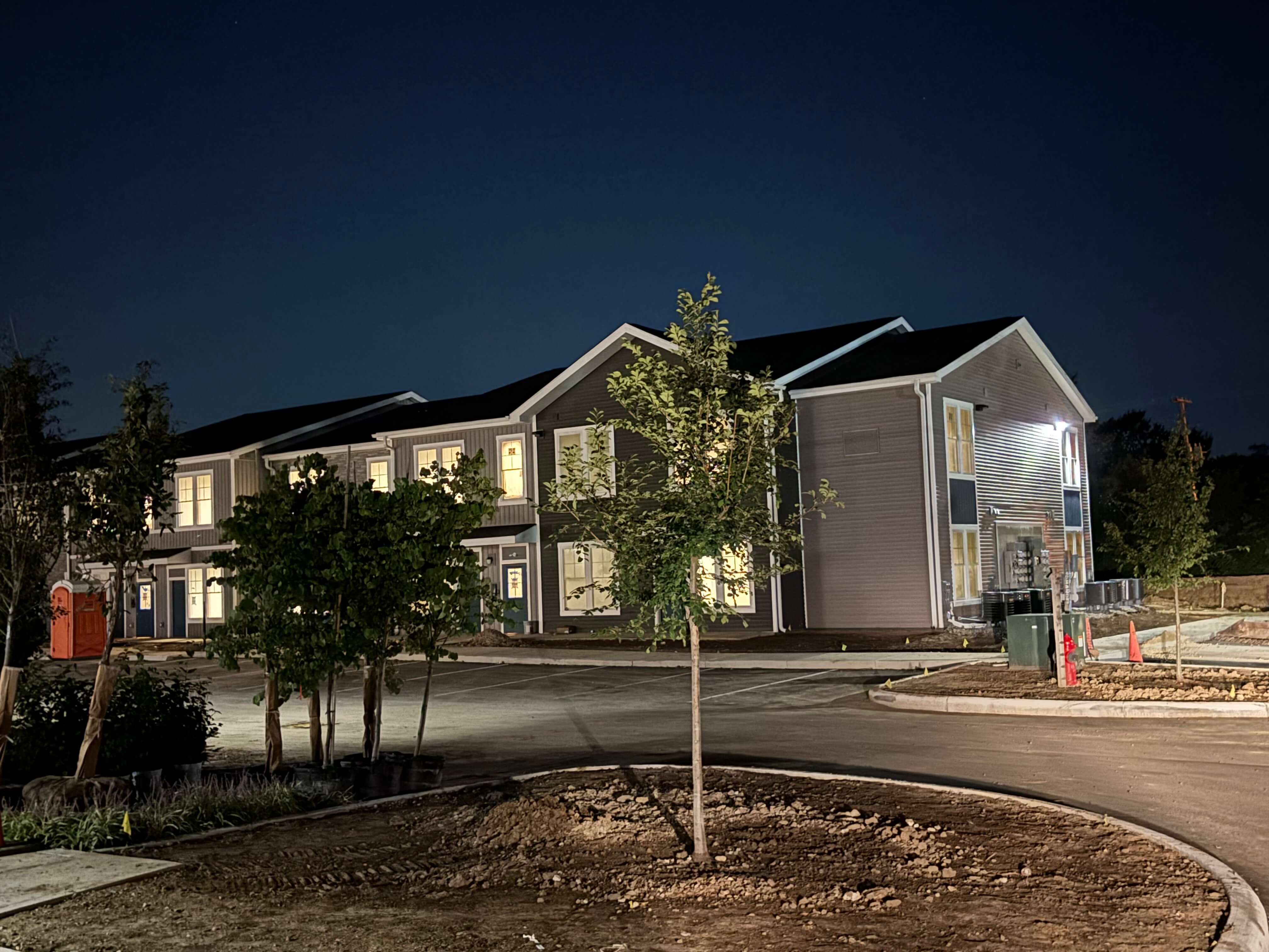 Exterior lighting illuminating new multi-unit residential building at night